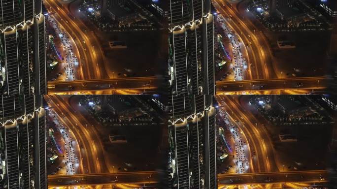 多层照明道路从夜间鸟瞰迪拜哈利法塔在阿联酋。高速公路岔路口交叉口。高速公路上车辆的俯视图。建筑结构。