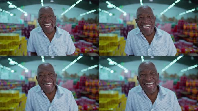 一位快乐的巴西黑人老人微笑着站在杂货棚里，身后是消费品