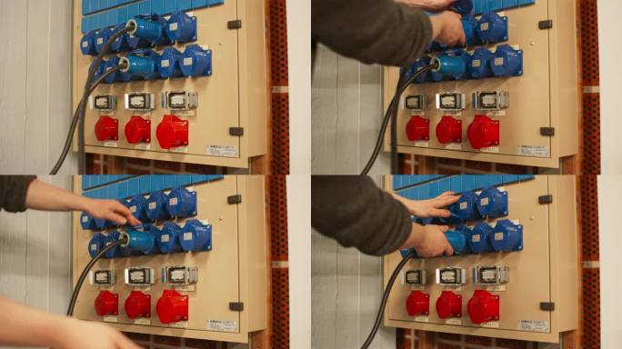 电气面板与蓝色16A和红色32A三相连接器和配电箱。技术人员拔掉不同排插座上的两根16A电缆。