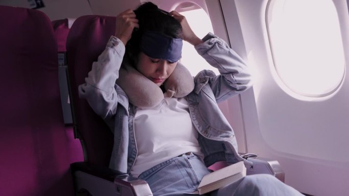 亚洲女性游客在休息日去度假时看书、蒙住眼睛避光、小睡一会儿。为了方便，她乘飞机旅行。