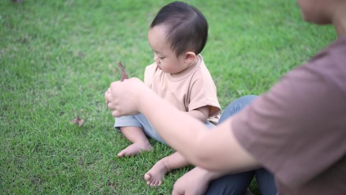 母亲带着男婴在公园户外玩耍