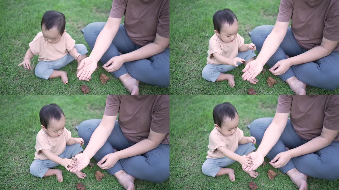 母亲带着男婴在公园户外玩耍