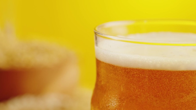 泡沫啤酒在玻璃特写纹理。酒精金色啤酒杯喝。新鲜的淡色麦酒。