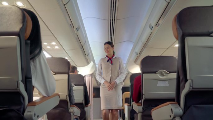 女乘务员在飞行前与乘客一起检查安全带的准备情况