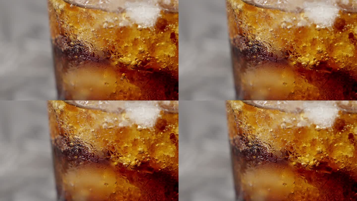 一个棕色软饮料的特写镜头，在一个冒泡的杯子里加了冰