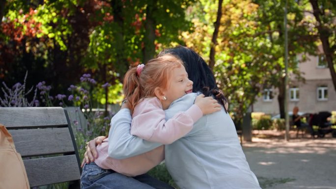 快乐的小女孩在公园外拥抱她的祖母。