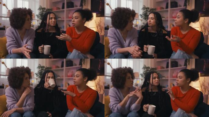 三个非裔美国女性朋友在家庭聚会上闲聊和喝茶