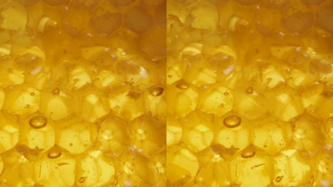 从宏观上看，蜂蜜滴下天然的金色蜂蜡梳。滑块垂直视频。