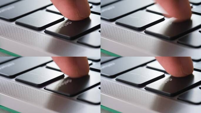 电脑用户的手指，他按下了电脑键盘上的删除键