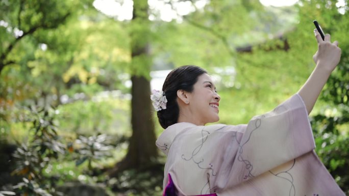 快乐的女游客穿着和服用手机旅游日本