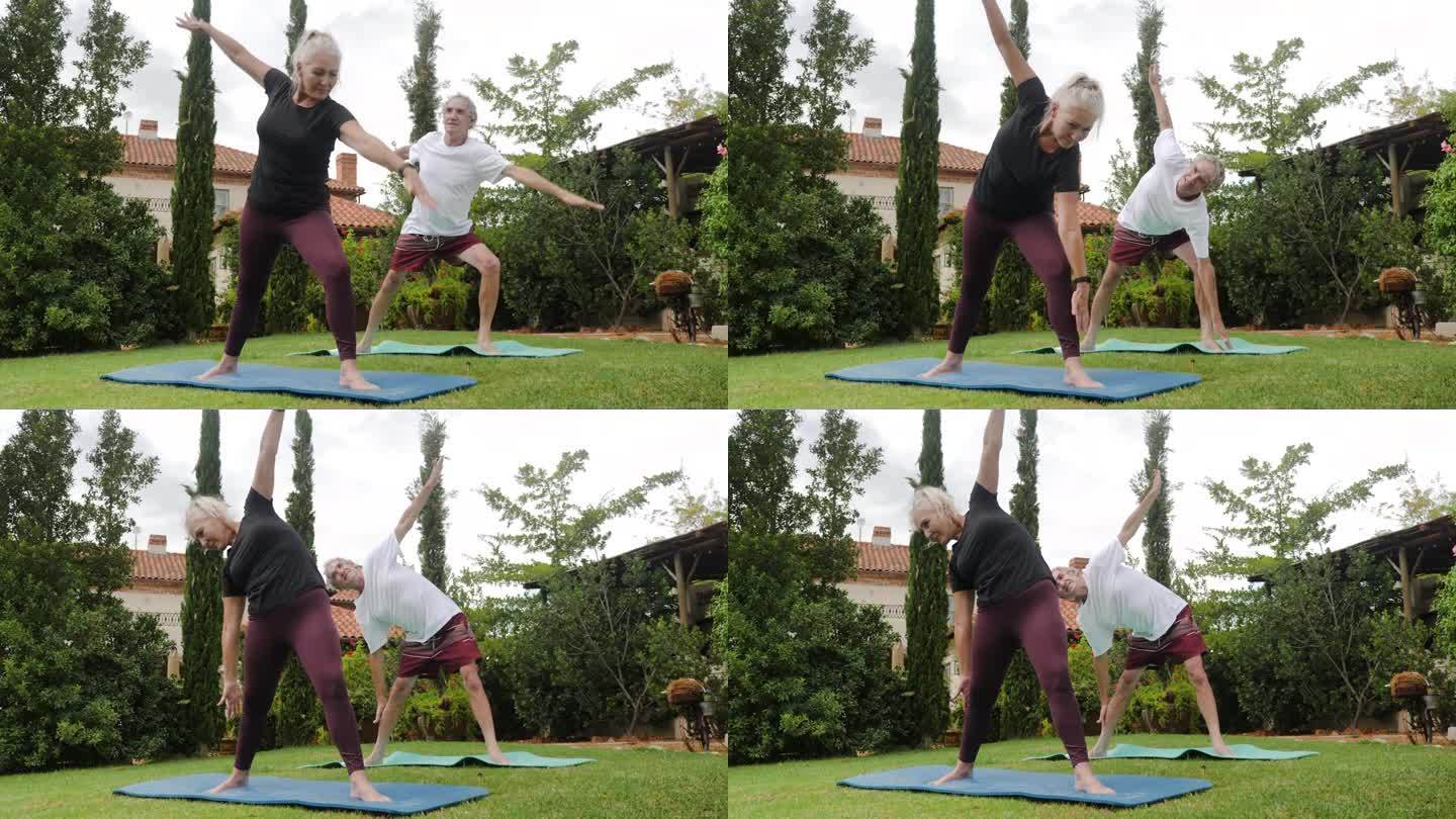 快乐，活跃的老年夫妇在别墅花园练习瑜伽