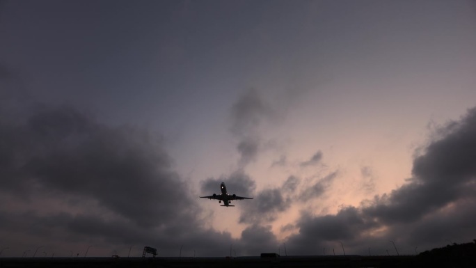 黄昏时分，一架客机从头顶飞过，降落在机场
