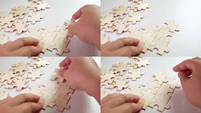 一个人试着在没有图片的情况下玩拼图游戏，他的手握住拼图的各个部分，而右手则把拼图一块接一块地加上去。