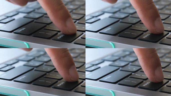 电脑用户的手指，他按下了电脑键盘上的删除键