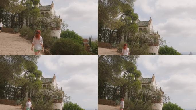 一名女子正走向安东尼·高迪设计的巴塞罗那Guell公园的Casa Trias