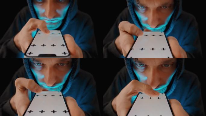 智能手机屏幕上的蓝光照亮了这个穿着卫衣的年轻人的脸，他正在用手指滑动页面。色度键模型。