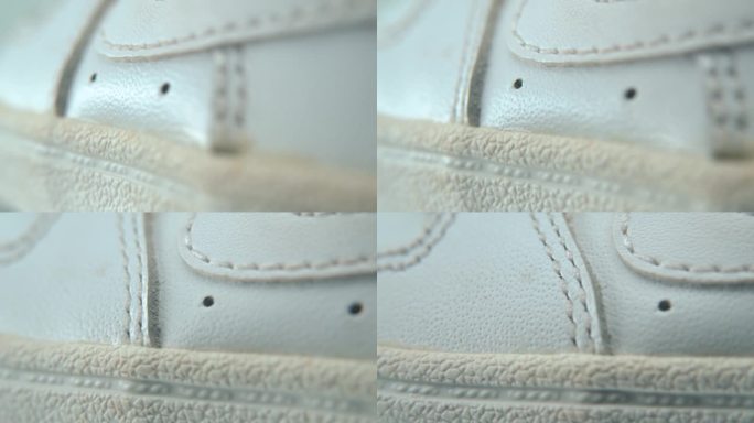 白色运动鞋鞋底的微距特写镜头，360度旋转支架上的微型鞋子展示，反射，孔和缝线，运动服设计，专业照明