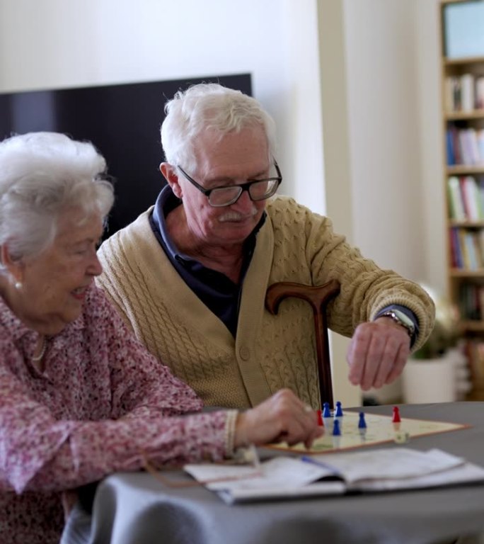 一对老年夫妇在家里玩棋盘游戏。恋爱中的老年情侣。