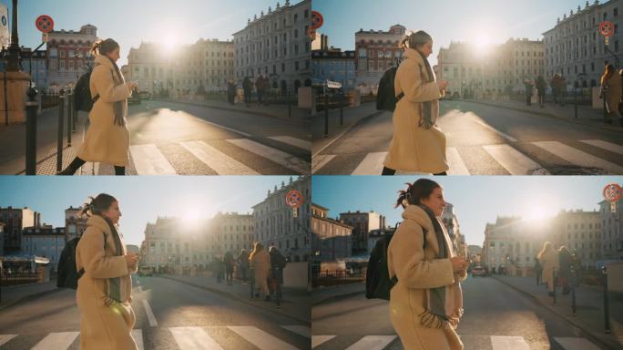 的里雅斯特市，年轻女性游客在过马路时使用智能手机的侧面照片