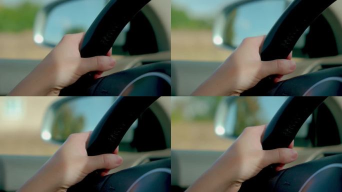 近距离拍摄的女性手握方向盘，她驾驶的汽车外镜反射