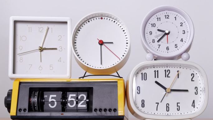 许多时间时钟在白色的背景告诉时间在速度，一个终身时钟的概念。