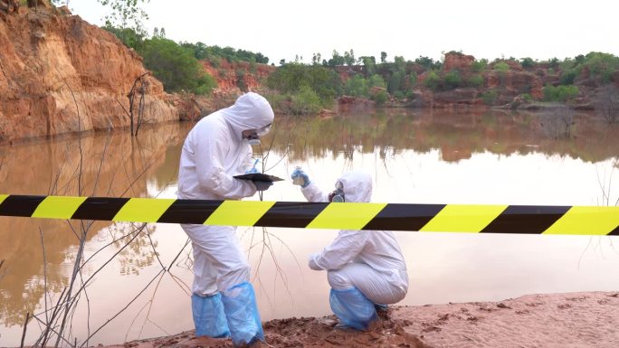 科学家们穿着化学防护设备和辐射防护服收集放射性污染水的样本。