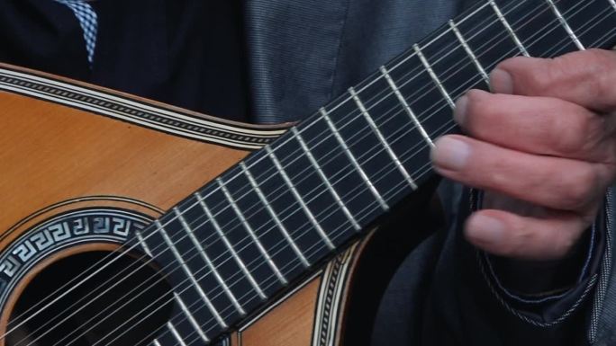 手指弹着传统的葡萄牙吉他。近距离