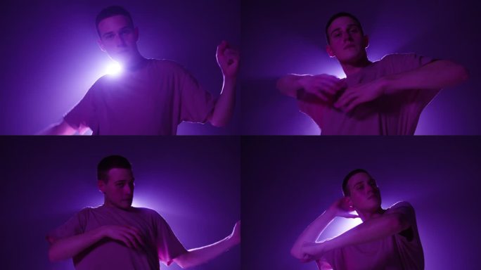 年轻人在工作室里用紫色的光在黑暗的背景上跳着现代舞。现代慢舞编舞的拍摄。男舞蹈编导在舞蹈动作中表达感
