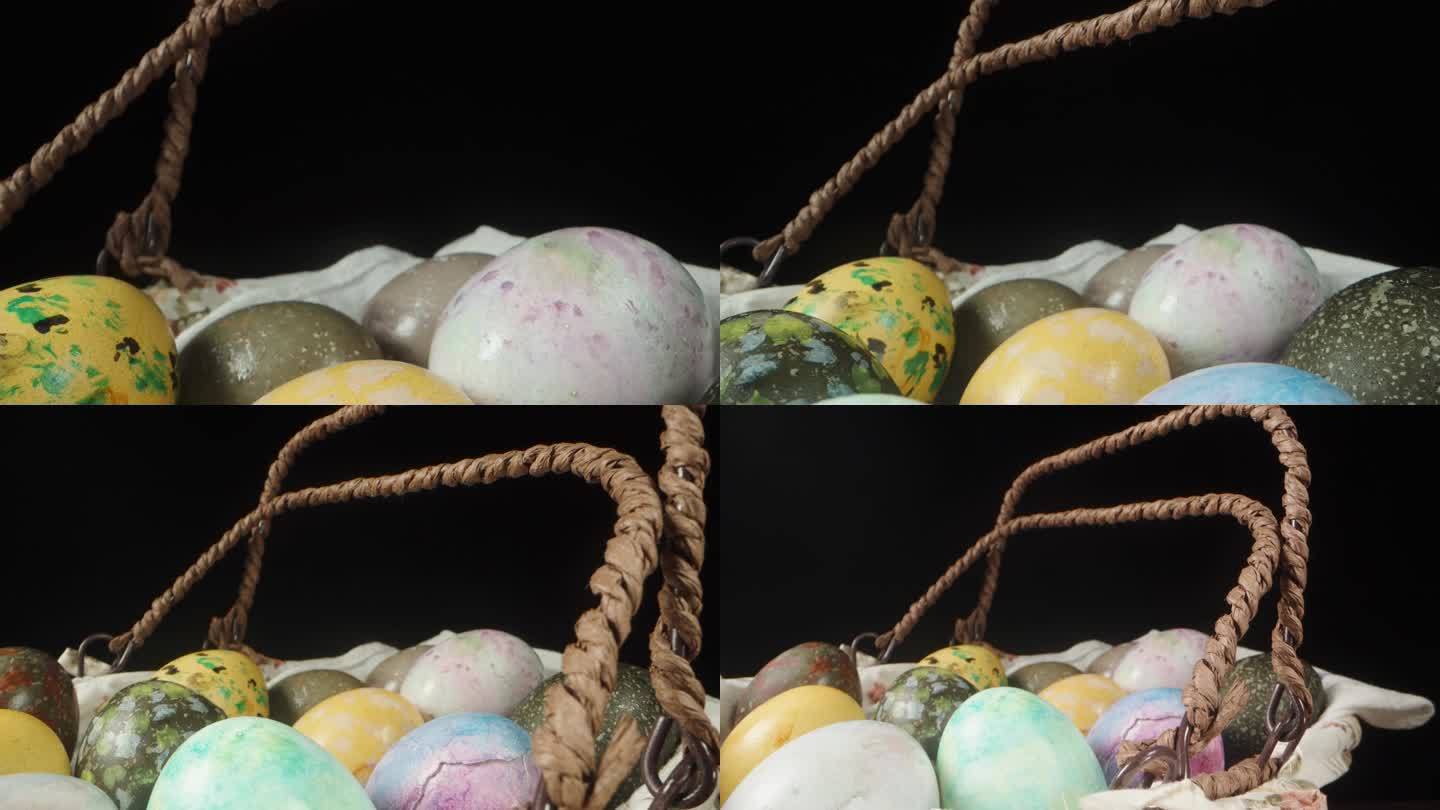 一个柳条篮子，提手凸起，上面有装饰好的复活节彩蛋。孤立的黑色背景，多莉滑块极端特写。