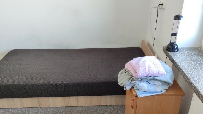 在学生宿舍里，打开的床和脏的床单。换床单