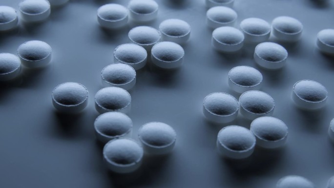 在科学实验室、医学研究和实验、原料药和安慰剂作用的药物中，有许多白色药丸在架子上旋转