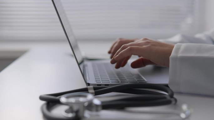医学专家将患者症状的详细记录保存在在线数据库中，为进一步研究和治疗创建完整的报告。手在键盘上打字的特