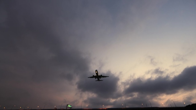 黄昏时分，一架客机从头顶飞过，降落在机场