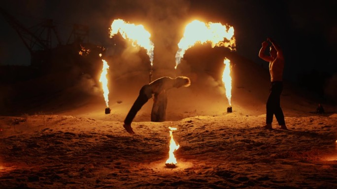 神秘的火灾表演和夜间户外马戏团表演，杂技演员跳跃和表演空翻