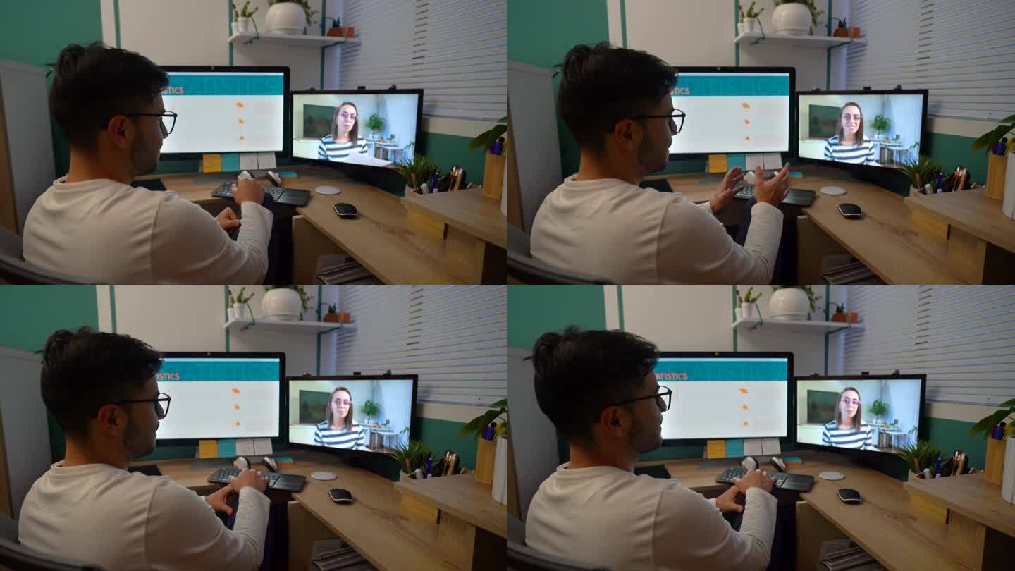 快乐的商人在家里用他的双屏台式电脑和一位女同事进行视频通话