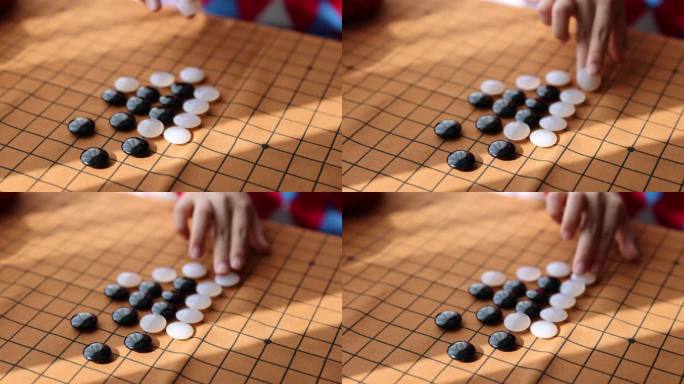 中国小孩在窗边下棋围棋