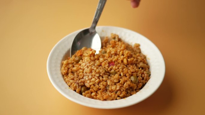 勺子在碗里挑选碾碎的米饭