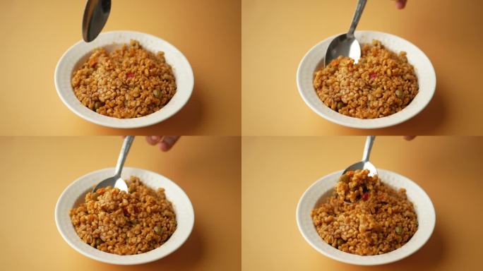 勺子在碗里挑选碾碎的米饭