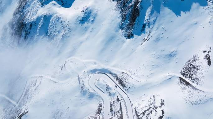 航拍一辆汽车行驶在夹金山雪山蜿蜒的盘山路