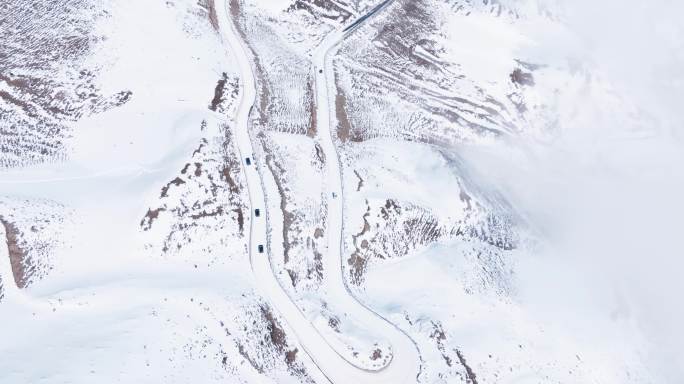 汽车行驶在冬季白雪覆盖的夹金山蜿蜒盘山路