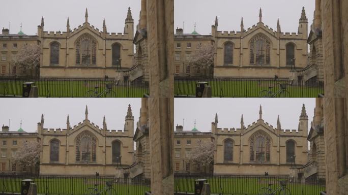 下雨天，牛津大学学院校门旁的学生自行车站着。学习牛津大学的教育理念