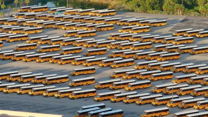 公立校车停车场，一排排的黄色巴士停在那里。美国教育体系