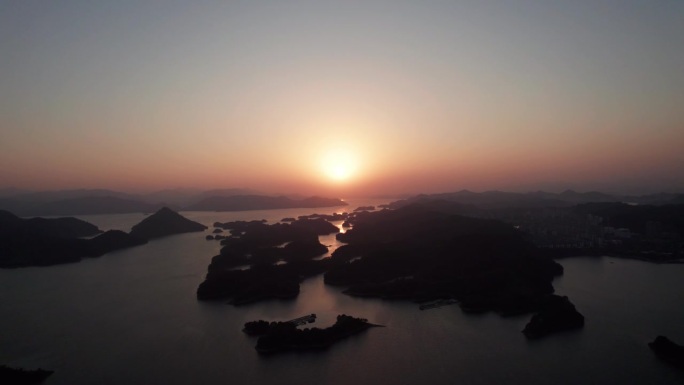 中国浙江杭州楚南千岛湖数千座岛屿鸟瞰图。美丽的日落在湖上，金色的太阳和剪影岛，4k实时镜头，无人机视