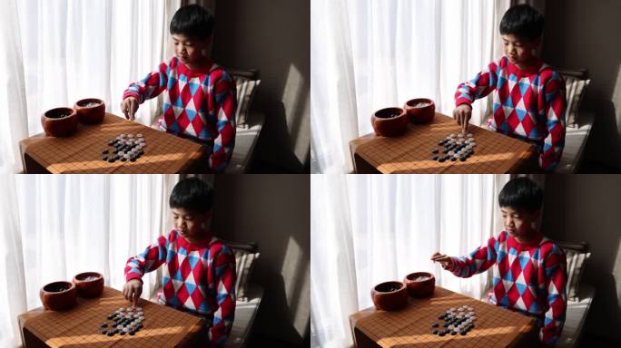 中国小孩在窗边下棋围棋