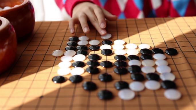 中国小孩在窗边下棋围棋手部特写