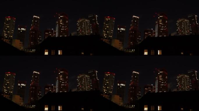 时间流逝:高大的现代摩天大楼的夜景与发光的窗户灯