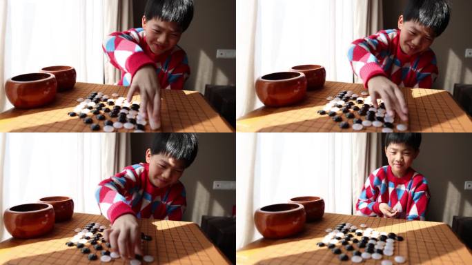 中国小孩在窗边下棋围棋