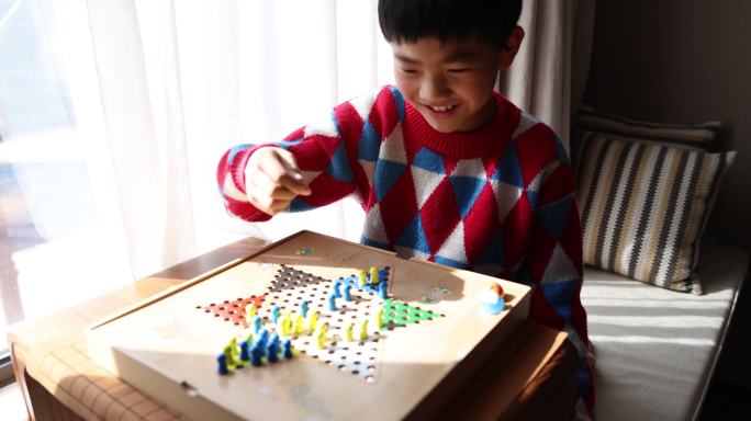 中国小孩在窗边下棋跳跳棋