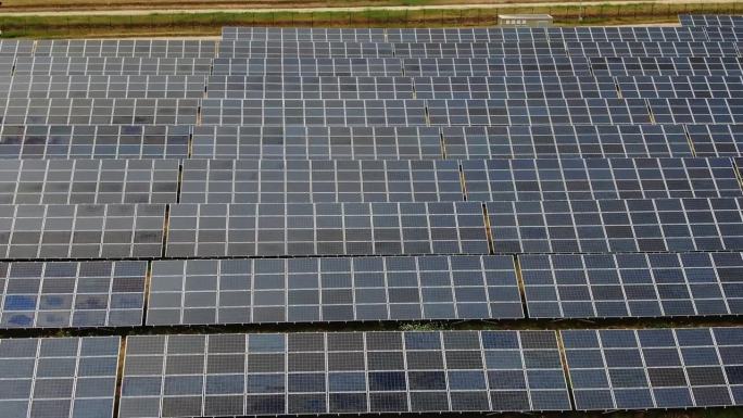 鸟瞰图的领域与运动的太阳能电池板，因为它放大。可再生能源。绿色能源。对环境的友好态度。世界环境规划署