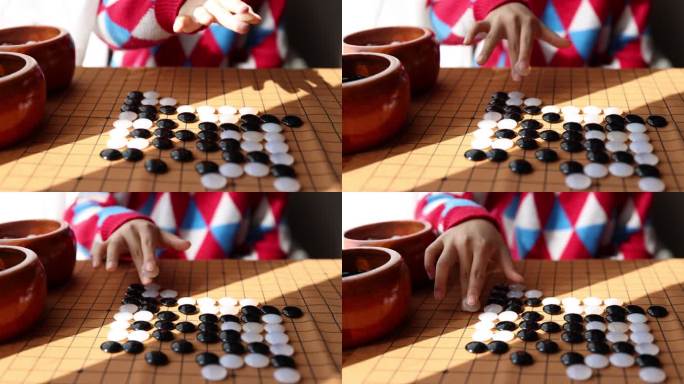 中国小孩在窗边下棋围棋手部特写